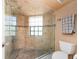 Tiled walk-in shower featuring glass doors, complemented by a toilet and towel rack at 3455 Countryside Blvd # 101, Clearwater, FL 33761