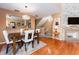 Elegant dining area with hardwood floors, stylish lighting, and a view into the modern kitchen at 3455 Countryside Blvd # 101, Clearwater, FL 33761