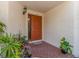 Warm and welcoming front entrance featuring a stylish door, brick walkway, and vibrant potted plants at 3455 Countryside Blvd # 101, Clearwater, FL 33761