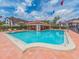 Community pool with colorful flags, lounge chairs, and a covered area at 3455 Countryside Blvd # 101, Clearwater, FL 33761