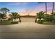 Wide view of a home at sunset, featuring a wide driveway, two-car garage, and tropical landscaping at 3617 Yellow Pine Ct # 144, Sarasota, FL 34238