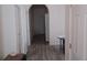 Hallway featuring a view of an arched entrance, wood-look floors, and a door on the right at 3680 19Th S Ave, St Petersburg, FL 33711