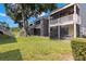 Exterior of two-story apartments with screened in patios, exterior stairs and a large shade tree at 4032 Cortez Dr # A, Tampa, FL 33614