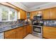 Kitchen features stainless steel appliances, wooden cabinets, granite counters, and modern tiled backsplash at 4032 Cortez Dr # A, Tampa, FL 33614
