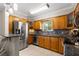 Kitchen features stainless steel appliances, wooden cabinets, and a granite countertop breakfast bar at 4032 Cortez Dr # A, Tampa, FL 33614