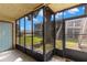 Enclosed screened-in porch with tile floor and a view of the community lawn and stairs at 4032 Cortez Dr # A, Tampa, FL 33614