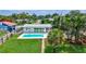 Aerial view of home featuring a pool, backyard, mature trees, and landscaping at 4099 Pompano Se Dr, St Petersburg, FL 33705