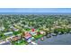 Aerial view of a waterfront home with a pool, dock, and lush landscaping in a neighborhood setting at 4099 Pompano Se Dr, St Petersburg, FL 33705
