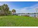 Waterfront backyard featuring a boat dock, mature trees, and lush landscaping at 4099 Pompano Se Dr, St Petersburg, FL 33705