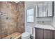 Bathroom with shower, natural stone tile, modern vanity, and updated fixtures at 4099 Pompano Se Dr, St Petersburg, FL 33705