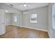 Bright bedroom featuring wood-look floors, mirrored closet doors, and windows at 4099 Pompano Se Dr, St Petersburg, FL 33705