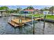 Private boat dock featuring boat lift, wooden walkway with railing, and an expansive view of the water at 4099 Pompano Se Dr, St Petersburg, FL 33705
