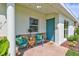 Inviting front porch with stone accents, seating, and a cheerful blue door at 4099 Pompano Se Dr, St Petersburg, FL 33705
