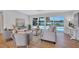 Cozy living room with serene water views through large windows and access to the pool area at 4099 Pompano Se Dr, St Petersburg, FL 33705