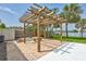 Backyard featuring a pergola over a brick paver patio, and tropical landscaping at 4099 Pompano Se Dr, St Petersburg, FL 33705