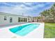 Backyard with a swimming pool, spacious patio, lush landscaping, and pergola at 4099 Pompano Se Dr, St Petersburg, FL 33705