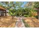 Paver pathway leads to a brick patio with seating, surrounded by lush landscaping in this inviting backyard at 419 W Osborne Ave, Tampa, FL 33603