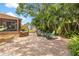 Landscaped backyard features a brick patio, cozy seating, and vibrant tropical foliage for outdoor enjoyment at 419 W Osborne Ave, Tampa, FL 33603