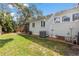 Green grass surrounds the house and shows the screened porch, creating a large space in the backyard at 419 W Osborne Ave, Tampa, FL 33603
