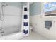 Bright bathroom with tub/shower combination, subway tile surround, and window at 419 W Osborne Ave, Tampa, FL 33603