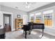 Bright bonus room featuring a piano, ceiling fan, and natural light streaming through large windows at 419 W Osborne Ave, Tampa, FL 33603
