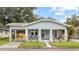 Charming bungalow-style home with inviting front porch, lush landscaping, and covered parking at 419 W Osborne Ave, Tampa, FL 33603
