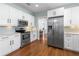 Well-lit kitchen featuring stainless steel appliances, white cabinets, and tiled backsplash at 419 W Osborne Ave, Tampa, FL 33603
