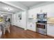 Kitchen with stainless steel appliances, white cabinetry, and view to a dining and living area at 419 W Osborne Ave, Tampa, FL 33603