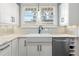 Close-up of a kitchen sink area with white cabinets and stainless steel appliances at 419 W Osborne Ave, Tampa, FL 33603