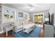 Inviting living room with hardwood floors, a plush sofa, and access to a screened-in porch at 419 W Osborne Ave, Tampa, FL 33603