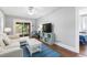 Comfortable living room with access to the porch, blue accents, and hardwood floors at 419 W Osborne Ave, Tampa, FL 33603