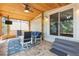 Covered back porch with ceiling fan, comfortable seating, and views of the backyard at 419 W Osborne Ave, Tampa, FL 33603