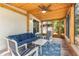 Covered porch with comfortable seating and view of the backyard's fence at 419 W Osborne Ave, Tampa, FL 33603
