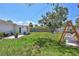 Spacious backyard featuring lush green grass, a swing set, and comfortable outdoor seating for relaxation at 4321 Sunrise S Dr, St Petersburg, FL 33705