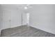A well-lit bedroom with neutral walls, a ceiling fan, and modern flooring; a door leads to other rooms at 4321 Sunrise S Dr, St Petersburg, FL 33705