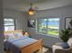 Bedroom featuring a ceiling fan, a light wood bed frame, and a view of the water at 4321 Sunrise S Dr, St Petersburg, FL 33705