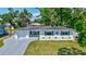 Charming single-story home with a well-manicured lawn, a paved driveway, and delightful blue exterior accents at 4321 Sunrise S Dr, St Petersburg, FL 33705