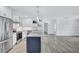Bright, modern kitchen with stainless steel appliances, white cabinets, quartz countertops, and a trendy navy blue island at 4321 Sunrise S Dr, St Petersburg, FL 33705