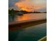 Picturesque waterfront view with a boat docked and vibrant sunset colors reflecting on the calm water at 4321 Sunrise S Dr, St Petersburg, FL 33705