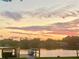 Picturesque waterfront view at sunset featuring a private dock and a small boat by the water at 4321 Sunrise S Dr, St Petersburg, FL 33705