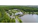 Scenic aerial view of a community clubhouse with a pond, and lush landscaping at 4345 Cadence Loop, Land O Lakes, FL 34638