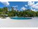 Large community pool featuring a slide, chairs with umbrellas, and tropical landscaping at 4345 Cadence Loop, Land O Lakes, FL 34638