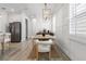 Bright dining room features a modern chandelier, wainscoting, and neutral tones creating an elegant atmosphere at 4345 Cadence Loop, Land O Lakes, FL 34638
