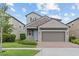 Charming two-story home featuring stone accents, a brick driveway, and well-maintained landscaping at 4345 Cadence Loop, Land O Lakes, FL 34638