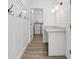 Well-lit laundry room featuring a white counter and shiplap accent wall, providing a functional and stylish space at 4345 Cadence Loop, Land O Lakes, FL 34638