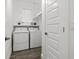 Neat laundry room with a side-by-side washer and dryer, wood-look tile floor, and storage shelves at 4345 Cadence Loop, Land O Lakes, FL 34638