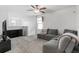 Cozy living room with a comfortable gray sectional sofa, a ceiling fan, and an entertainment center at 4345 Cadence Loop, Land O Lakes, FL 34638