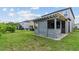 View of the screened in back patio showing the paved area and the beautiful green backyard at 4345 Cadence Loop, Land O Lakes, FL 34638