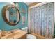 Bathroom with blue walls, decorative mirror, and shower-tub combo with patterned curtain at 4499 Collins Rd, Spring Hill, FL 34606