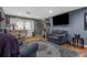 Cozy living room features hardwood floors, a comfortable couch, and a large television screen at 4499 Collins Rd, Spring Hill, FL 34606